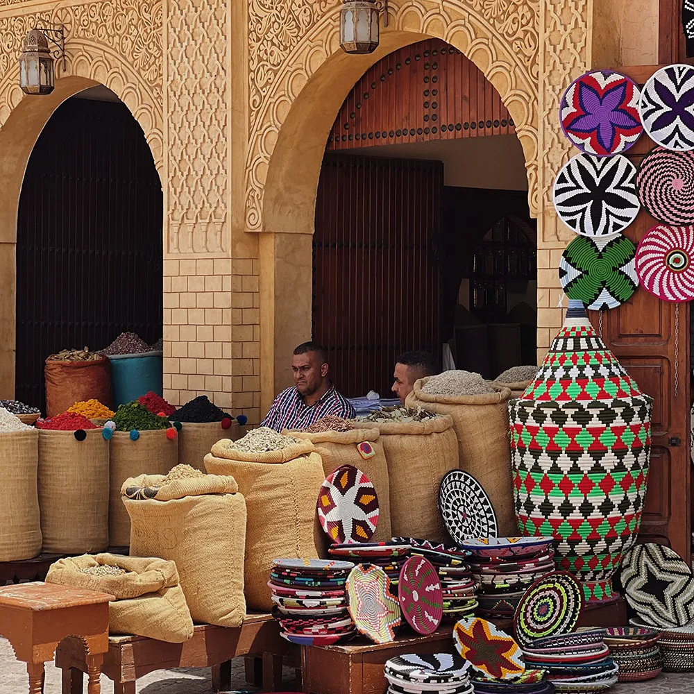 Bolsas y mantas artesanales junto a arcos de arquitectura tradicional marroqu&iacute;
